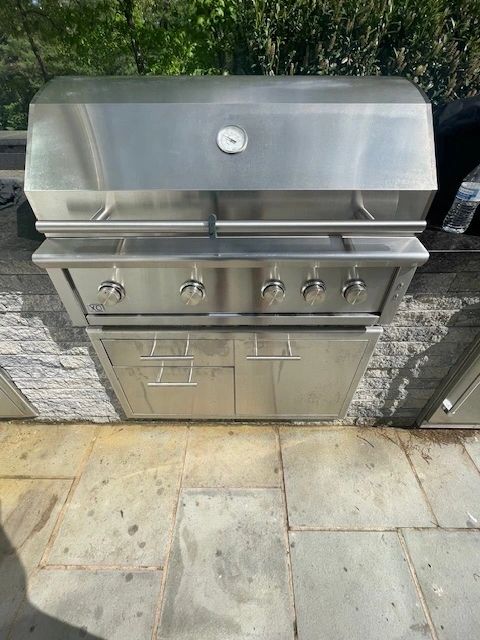 Stainless steel outdoor gas grill on stone patio